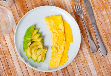 Omelet served with avocado on platter
