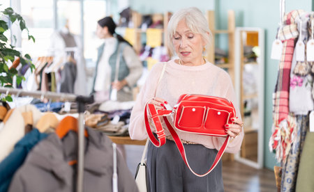 Regular customer senior woman chooses color and style of handbagの写真素材