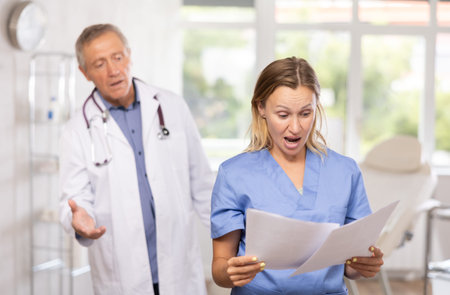 Female doctor reads paper documents report and talks to elderly man