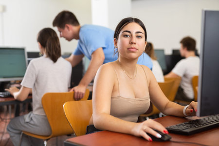 Concentrated female student using PC and studying computer science in the classroom
