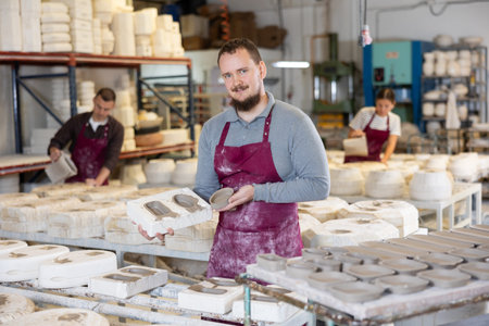 Ceramist explaining process of forming ceramic dishes in slipcasting molds
