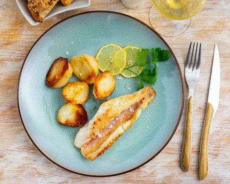 On plate, slice of fried redfish garnished with French fries