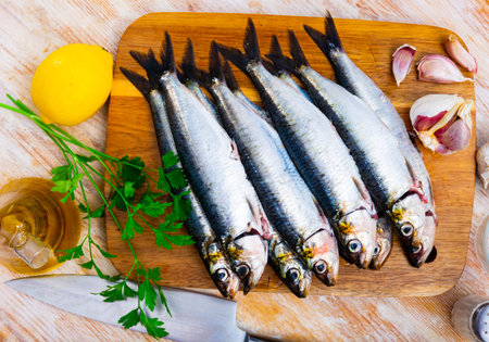 Raw sardines on wooden cutting boardの写真素材