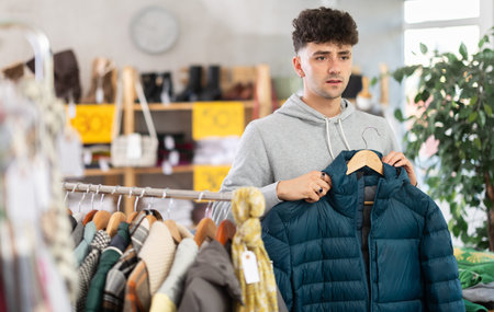 Regular customer guy chooses color and style of down jacket