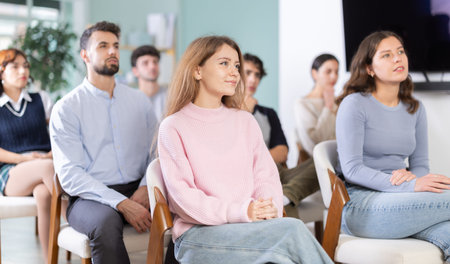 Group of young students listening during seminar in a modern classroom