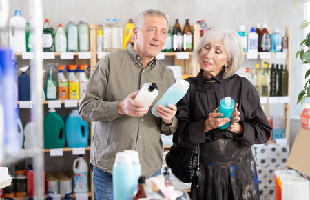 Husband and wife choose shampoo or shower gel together in supermarketの写真素材