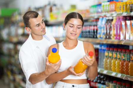 Married couple in supermarket buys bottle of soda drinkの写真素材