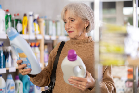 Mature woman choosing laundry detergent in department storeの写真素材