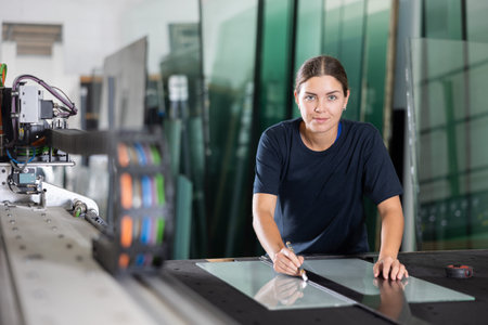 Glass workshop - girl marks glass for cutting with glass cutterの写真素材