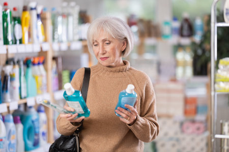 Mature woman choosing tooth care products in department storeの写真素材