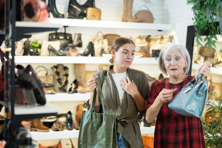 Young and elderly women choosing handbag in storeの写真素材