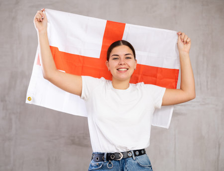 Portrait of positive young woman holding England flagの写真素材