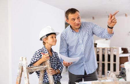 Father with little son talking about repair work in apartmentの写真素材