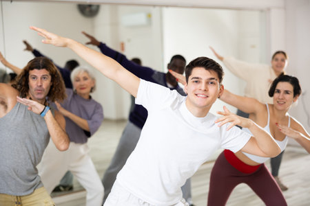 Happy caucasian man learning new modern dance in group dance lessonの写真素材