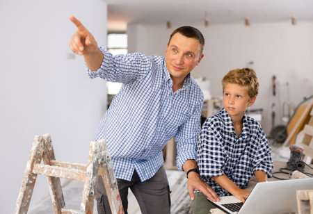 Man with son discussing renovating of homeの写真素材