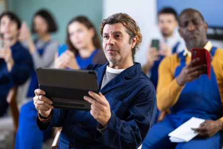 Worker take picture with mobile phone or photograph QR code on bulletin board in classroomの写真素材