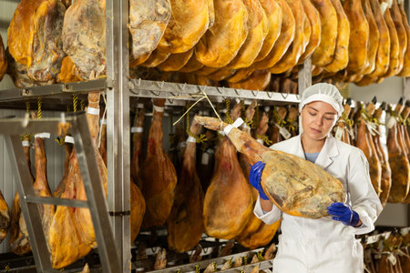Girl checks quality of spanish jamon in workshopの写真素材