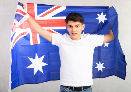 Surprised young guy holding flag of Australiaの写真素材