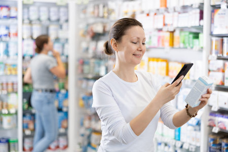 Adult woman looking for remedy from photo on internetの写真素材