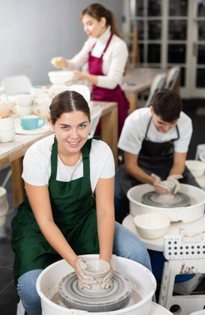Young woman sculpting product on potters wheelの写真素材