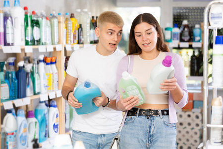 Couple man and woman choosing detergent in store