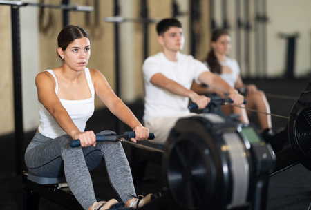 Young woman training her arms on machine