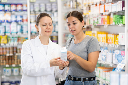 In cosmetic department of pharmacy, buyer asks consultant to help and choose cleansing gel.の写真素材
