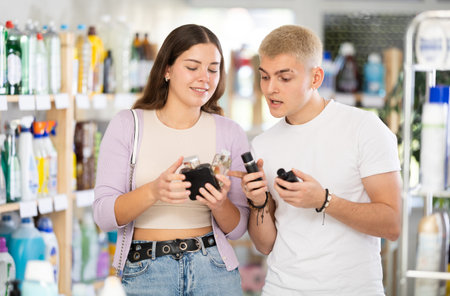 Couple man and woman choosing perfume in storeの写真素材
