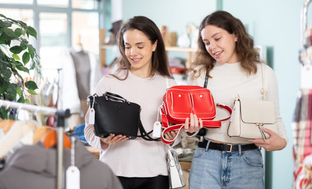 Two young women choosing handbag in storeの写真素材