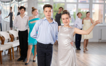 Smiling girls paired with guys dance in dance class