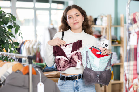 Young woman chooses lingerie in clothing storeの写真素材