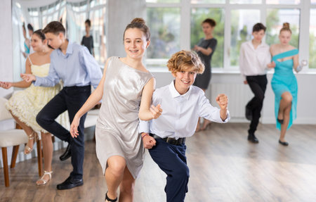 Happy teenage boys and beautiful girls dance fiery twist dance