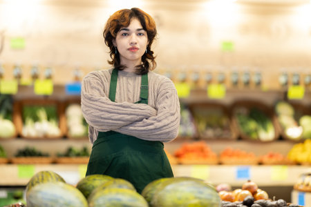 Portrait of young female grocery store employee in fruit and vegetable departmentの写真素材