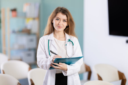 Young female doctor with folder invites in lecture hallの写真素材