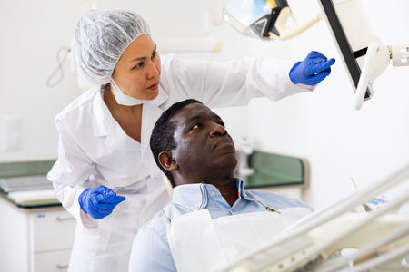Doctor dentist shows patient an x-rayの写真素材