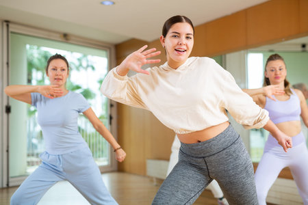 Positive people practicing vigorous lindy hop movements in dance class