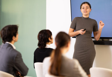 young woman giving a speech to a team of specialists