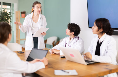 Young female doctor leading medical meeting in officeの写真素材