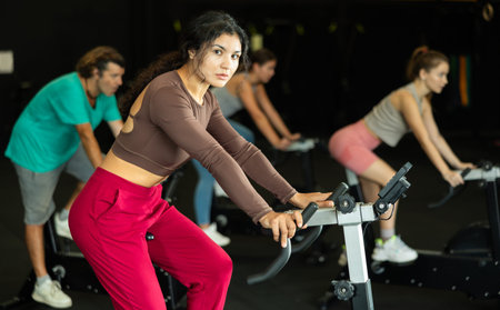 Latina woman exercising on an exercise bike in a crossfit gymの写真素材