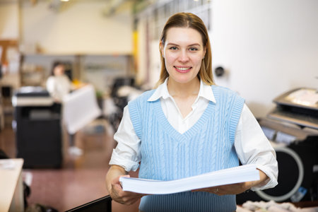 Portrait of happy woman with a stack of paper in her hands in typography