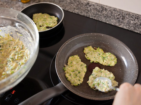 Fritters of courgettes are fried in panの写真素材