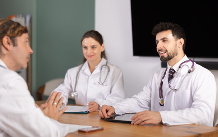 Medical professionals discussing topic during clinical meeting at tableの写真素材