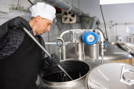 Portrait of brewer who is making beer on his workplace in brew-houseの写真素材