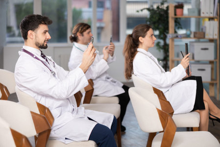 Medical students or doctors using mobile phones to scan QR-code during interactive lessonの写真素材