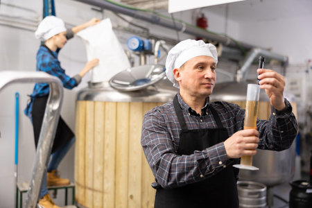 Brewer checks amount of alcohol in beer using an alcoholmeterの写真素材