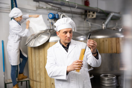 Man brewer indicating alcoholic strength of beer