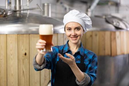 Happy woman brewer inviting to tasting amber beer