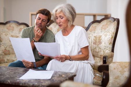 Helpful man helping elderly woman to sign documents
