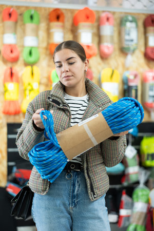 Girl view rope cable for climbing and evaluate its thickness