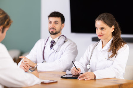 Medical professionals discussing topic during clinical meeting at table